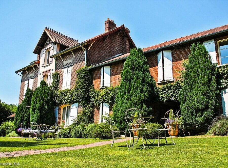 La maison de briques des Granges d’Haillancourt et son jardin, un jour d’été